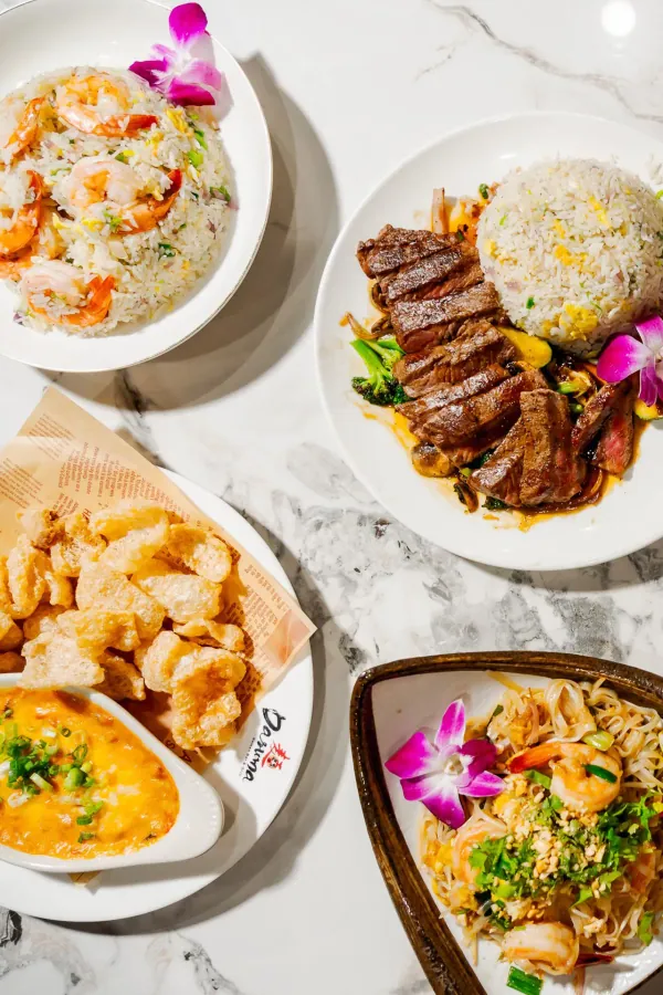 A spread of Japanese dishes, steak, fried rice, noodles and shrimp, shot from above