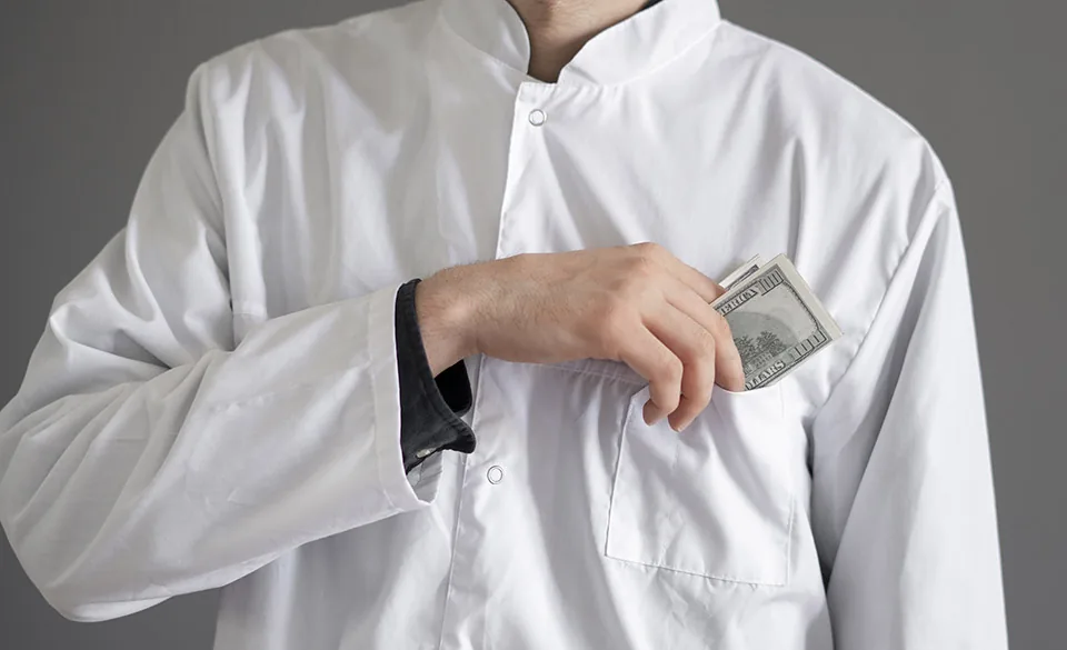 A chef tucking cash into a jacket pocket