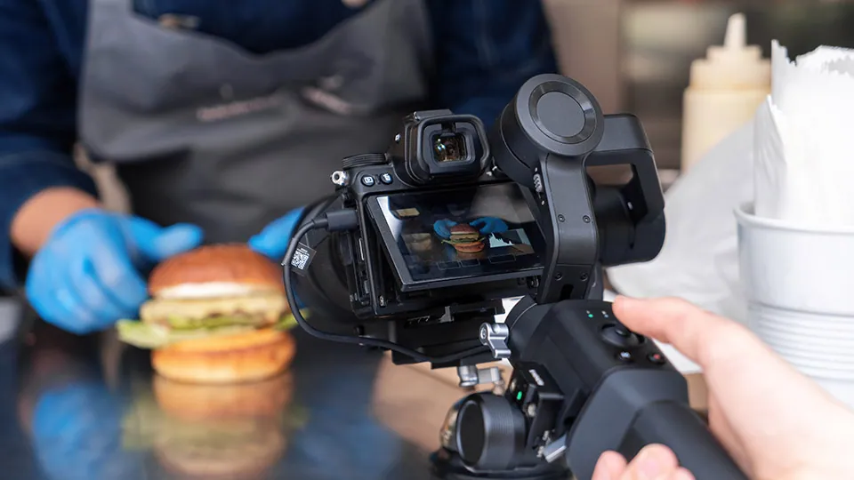Videographer filming a cook in the kitchen