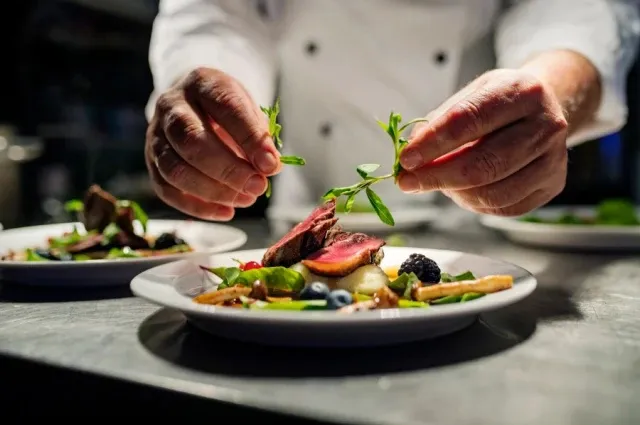 A chef plating a fine-dining dish