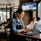 Restaurant manager planning while streaming TV plays