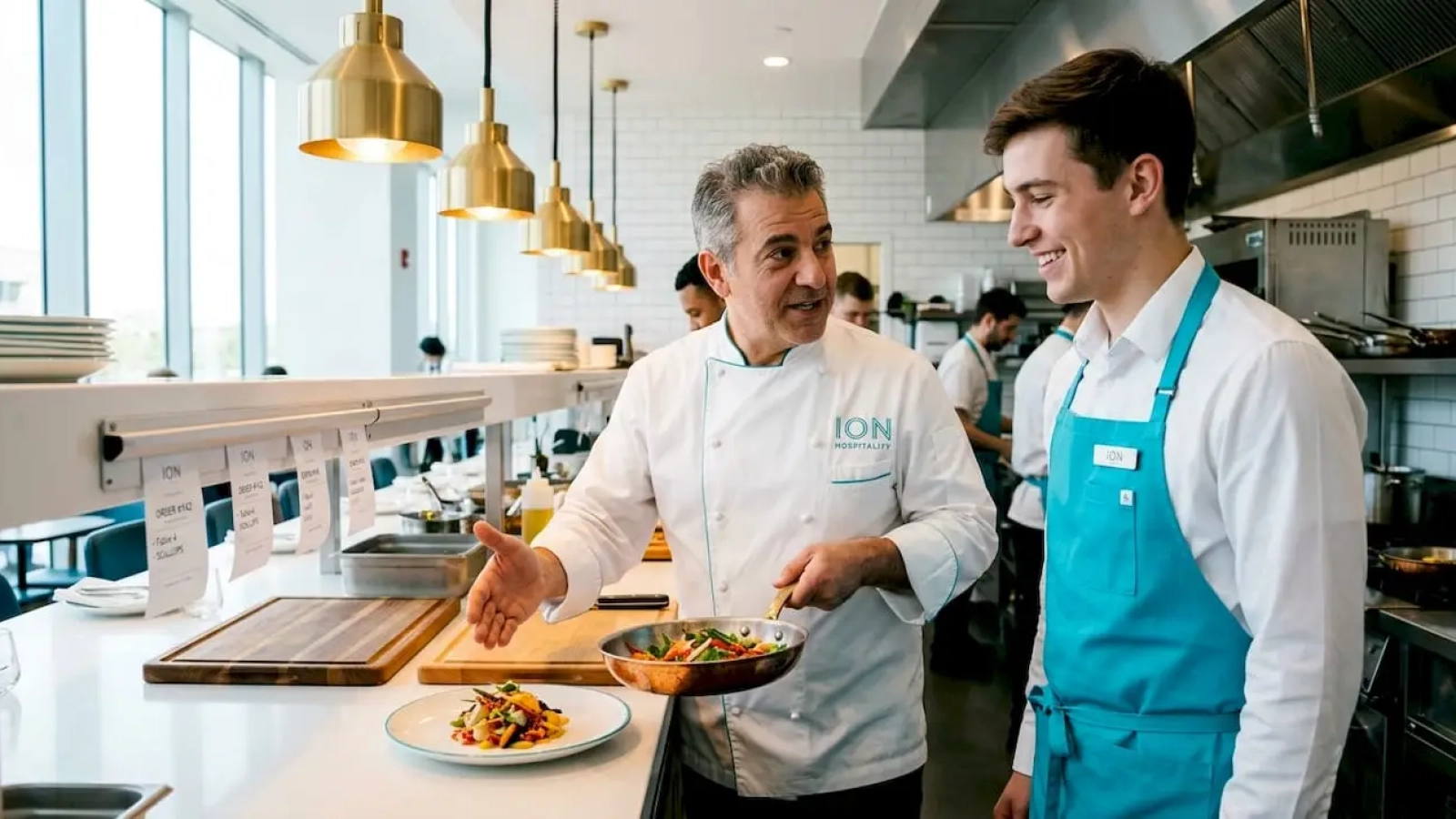 Chef storytelling to staff in busy kitchen