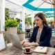 Restaurant manager typing content calendar at table