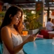 Woman browsing digital menu on smartphone at restaurant table