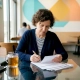 Restaurant owner reviewing community feedback cards