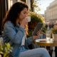 Woman reading restaurant reviews on smartphone at café