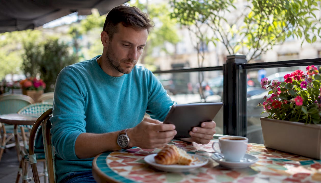 Hands holding tablet at café for restaurant marketing