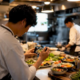Chef filming sizzling food in kitchen