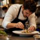 Chef plating new menu dish in restaurant kitchen